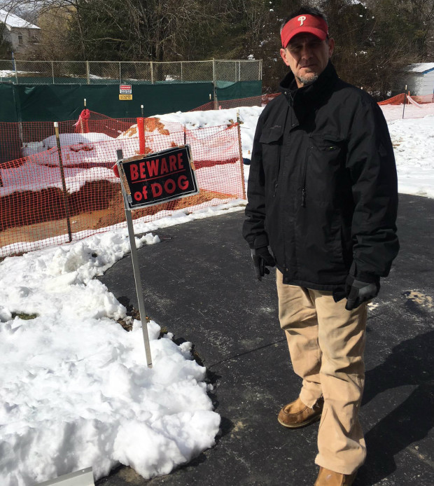 TJ Allen, a resident of West Whiteland Township in Chester County, stands in front of sinkhole enclosures in his back yard. Allen said he's worried about the sinkholes, and the fact that Sunoco has been ordered to make sure an existing pipeline that runs through his neighborhood is safe. 