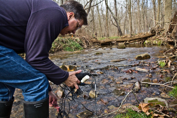 John Jackson, a senior research scientist at the Stroud Water Research Center, measuring conductivity at the White Clay Creek at the center.