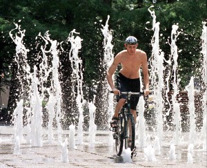 Chris Howell of Dallas gets a break from the stifling heat by riding his bicycle through the water sculpture at Fountain Place in downtown Dallas, TX, 20 July. Temperatures in Dallas topped the 100 degree mark (38 celsius) for the 15th day in a row.